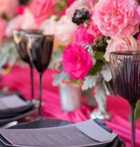 Elegant wedding setup featuring hot pink and ash grey elements, including flowers, linens, and accessories, showcasing a bold yet sophisticated theme.