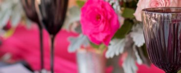 Elegant wedding setup featuring hot pink and ash grey elements, including flowers, linens, and accessories, showcasing a bold yet sophisticated theme.