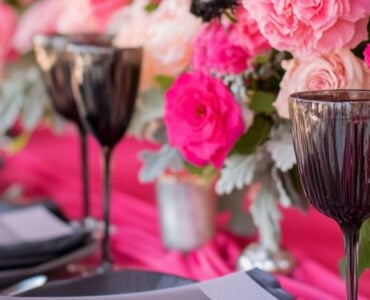 Elegant wedding setup featuring hot pink and ash grey elements, including flowers, linens, and accessories, showcasing a bold yet sophisticated theme.