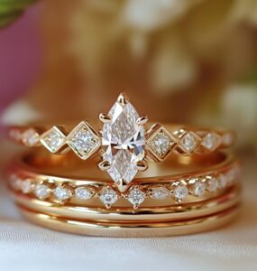 An elegant marquise wedding stack featuring a marquise engagement ring paired with diamond-accented wedding bands, set against a soft romantic background.
