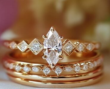 An elegant marquise wedding stack featuring a marquise engagement ring paired with diamond-accented wedding bands, set against a soft romantic background.