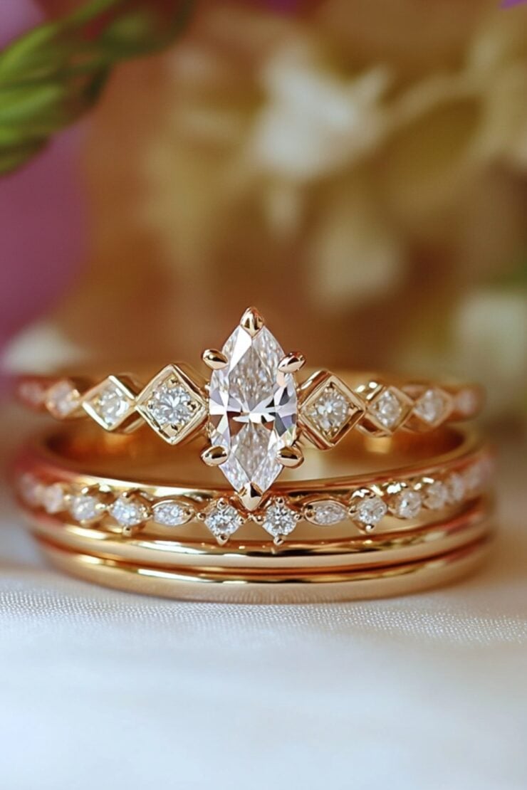An elegant marquise wedding stack featuring a marquise engagement ring paired with diamond-accented wedding bands, set against a soft romantic background.