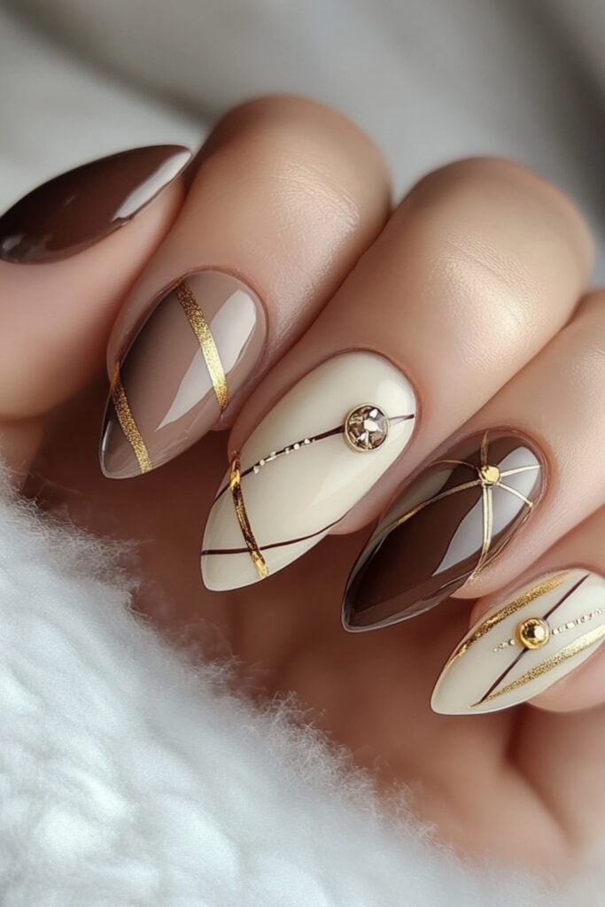 Minimalist nails featuring clean geometric patterns and tiny gold embellishments on a soft nude base for a modern look.