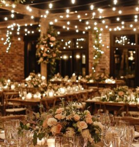 An elegant rustic wedding venue adorned with warm string lights and natural wooden elements, creating a cozy and romantic atmosphere for the celebration.
