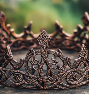 An intricately designed Viking bridal crown, showcasing historical artistry and symbolism, resting on a rustic wooden table, emphasizing Norse wedding traditions and cultural heritage.