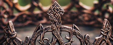 An intricately designed Viking bridal crown, showcasing historical artistry and symbolism, resting on a rustic wooden table, emphasizing Norse wedding traditions and cultural heritage.