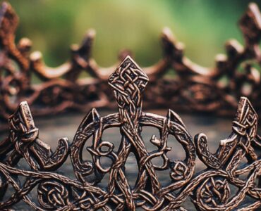 An intricately designed Viking bridal crown, showcasing historical artistry and symbolism, resting on a rustic wooden table, emphasizing Norse wedding traditions and cultural heritage.