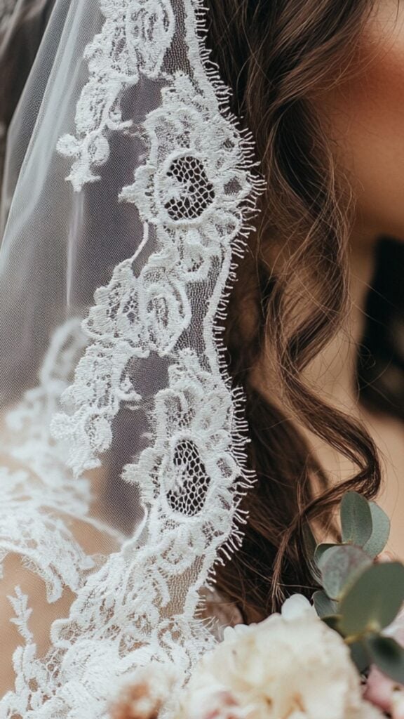 A close-up of a bride’s lace veil and floral bouquet, highlighting the intricate details that add charm and uniqueness to the wedding.