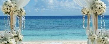 An elegant beach wedding scene with the ocean's natural beauty as a backdrop, emphasizing how different aesthetics can create a memorable and personalized celebration by the sea.
