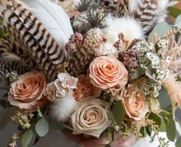 A boho wedding bouquet with a harmonious mix of textures, including feathers, romantic florals, and trailing ribbons, showcasing creative, personalized touches.