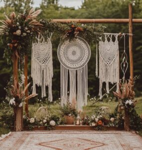 A beautifully decorated boho wedding ceremony with macramé backdrops, dreamcatchers, and greenery, set outdoors under soft, natural lighting.