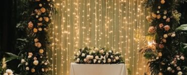 A romantic forest wedding ceremony setup with lush greenery, fairy lights, and an elegant floral backdrop.
