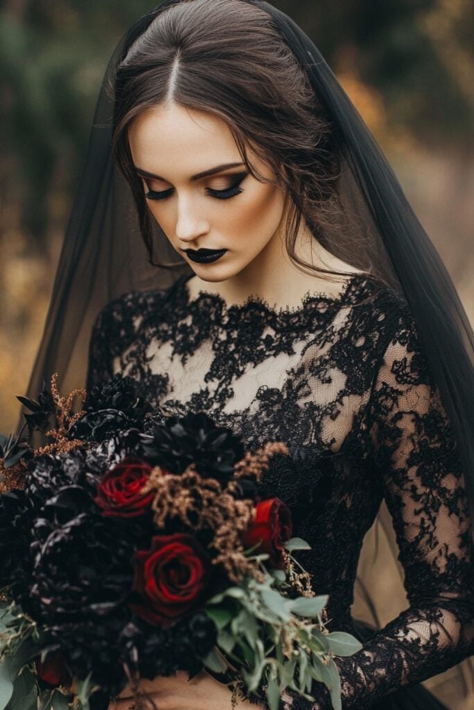 A gothic-inspired wedding dress with a black lace bodice, long sleeves, and a velvet skirt, complemented by a dramatic veil and dark floral bouquet.