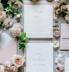 A flat-lay of modern wedding invitations featuring clean typography, floral accents, and soft color palettes with matching envelopes, setting an elegant tone.