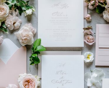 A flat-lay of modern wedding invitations featuring clean typography, floral accents, and soft color palettes with matching envelopes, setting an elegant tone.