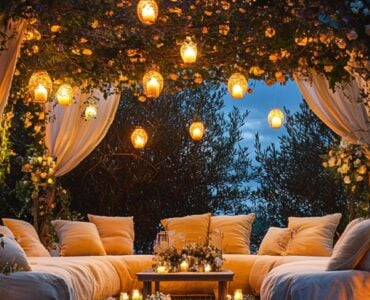 A magical outdoor wedding scene with glowing lanterns, a cozy seating area, and a floral arch, capturing the essence of a memorable celebration under the open sky.
