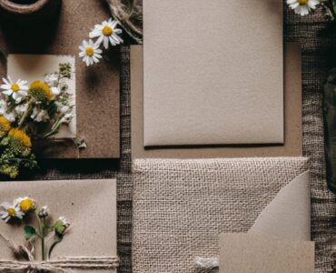 Flat lay of rustic wedding invitations featuring earthy materials like burlap, kraft paper, and wildflowers for a natural theme.