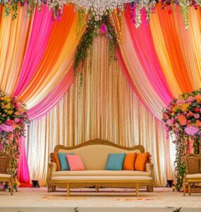 A beautifully decorated desi wedding venue with a grand stage, floral arrangements, and colorful drapery, setting the perfect mood for celebration.